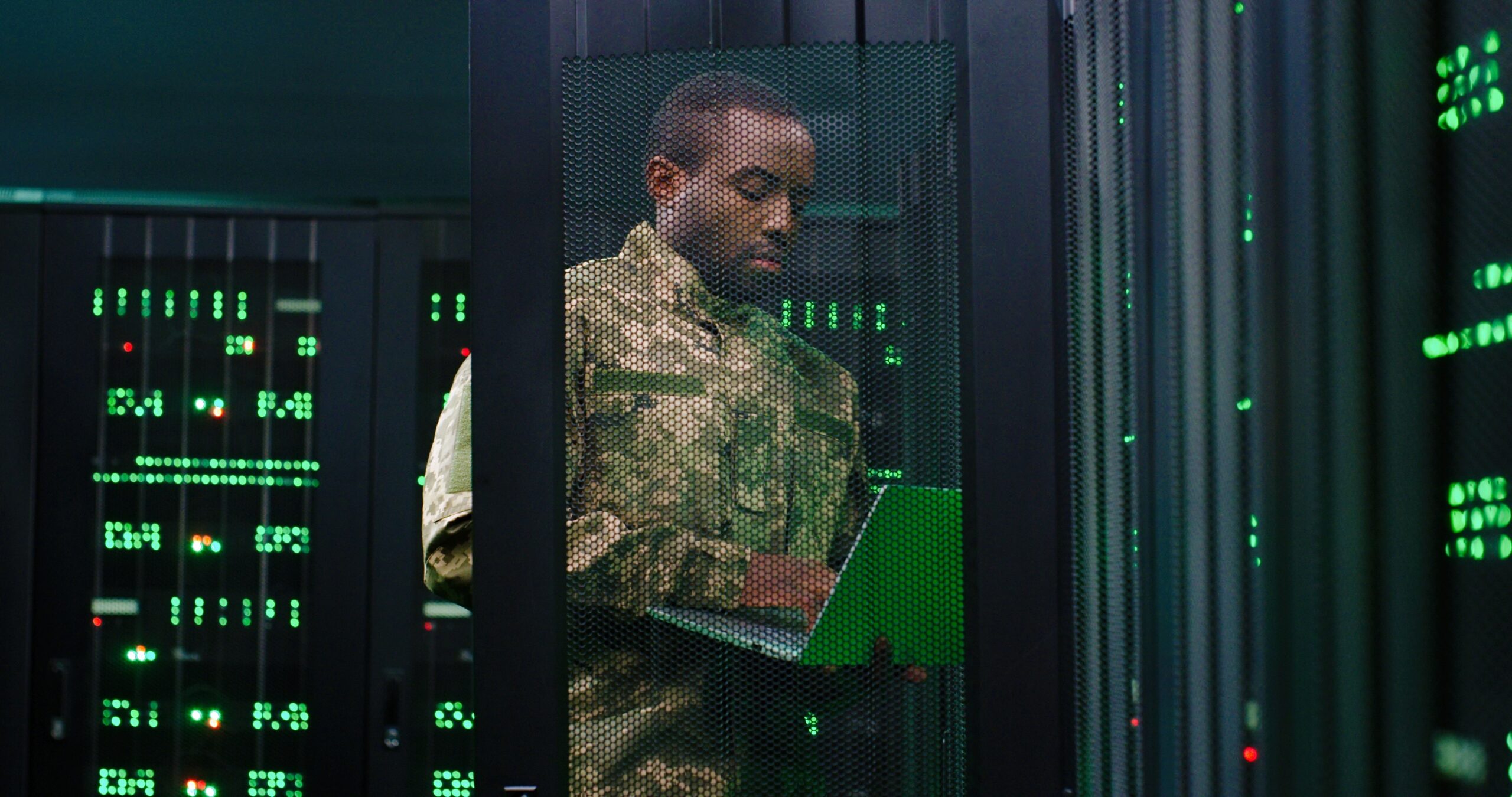 african american man in military uniform working on a laptop in a secure server room